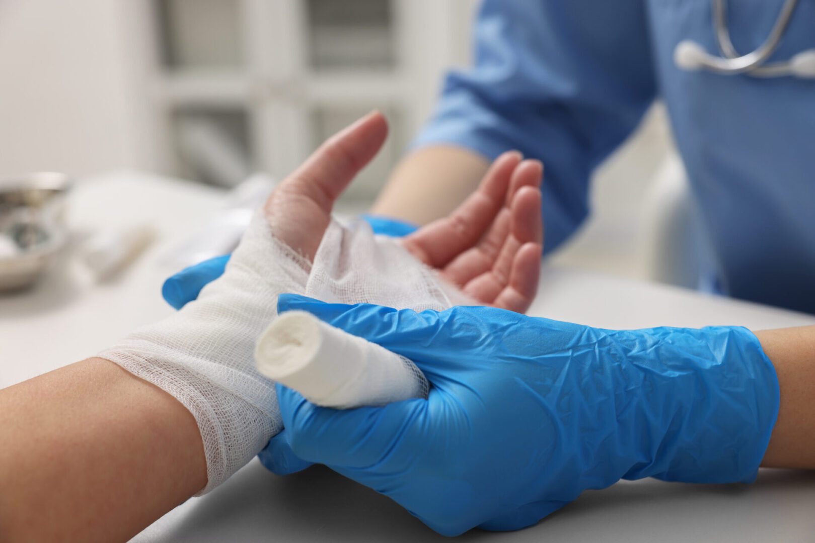 Nurse applying bandage to patient's hand.