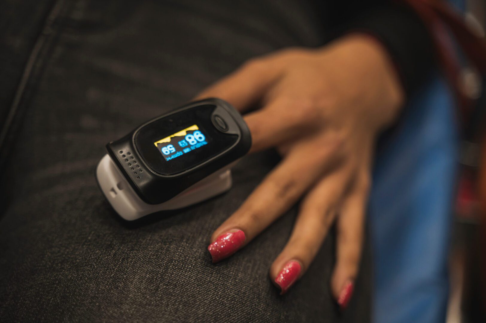 Hand with pulse oximeter on finger.
