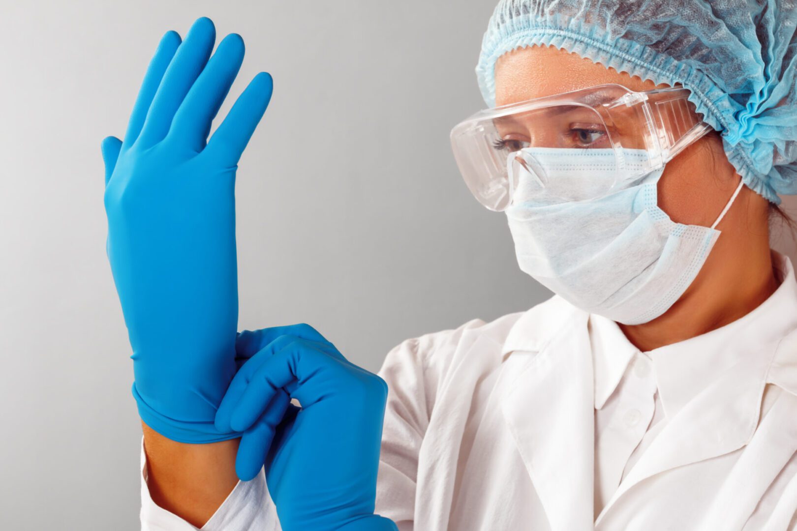 Healthcare worker wearing gloves and protective gear.